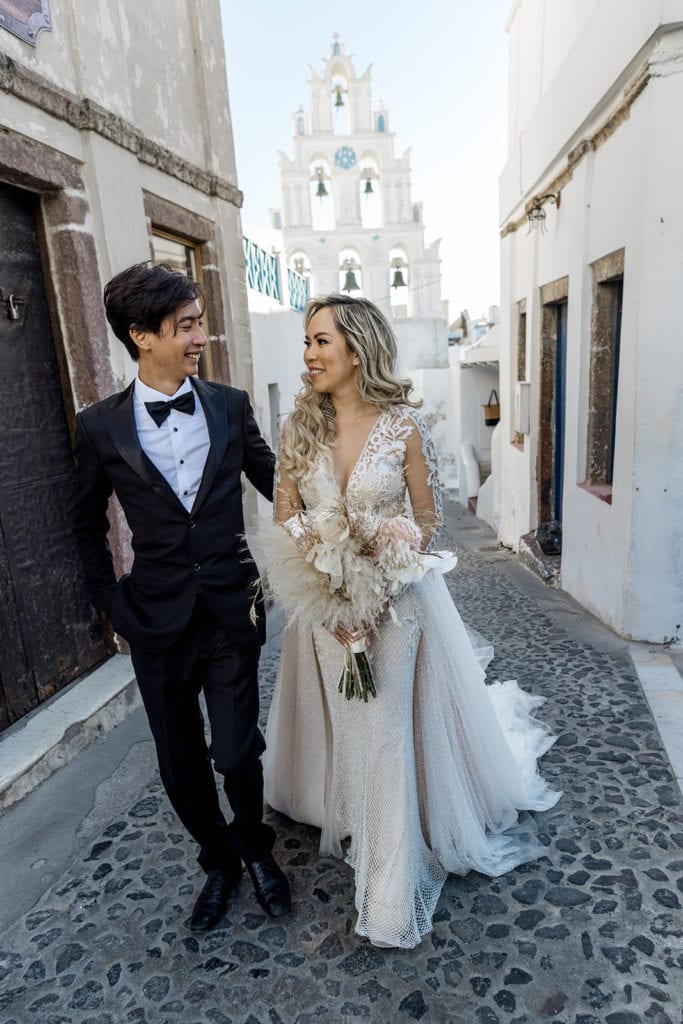 Bride and groom walking through streets of Santorini