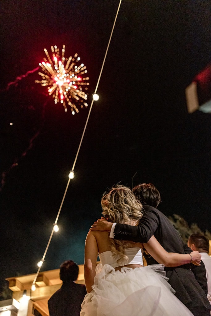 Bride and groom watch fireworks during Santorini wedding reception