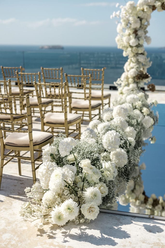 White floral ceremony aisle markers for Santorini waterfront wedding