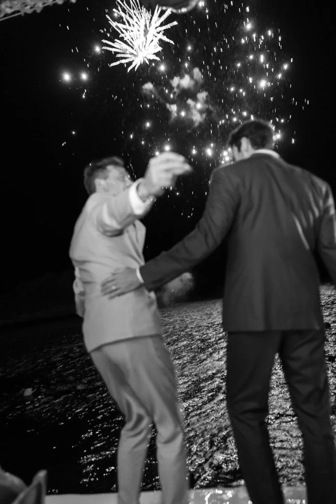 Grooms celebrate fireworks during Mykonos wedding reception