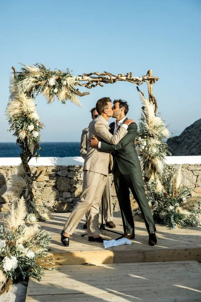 Grooms kiss during Mykonos wedding ceremony