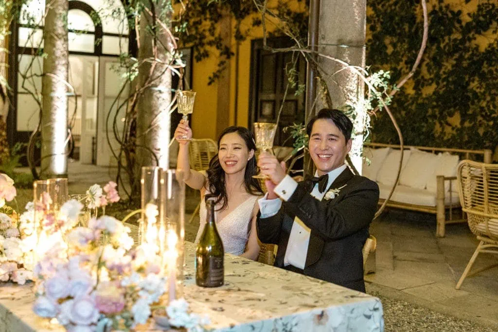 Bride and groom raise glasses in a toast during wedding reception