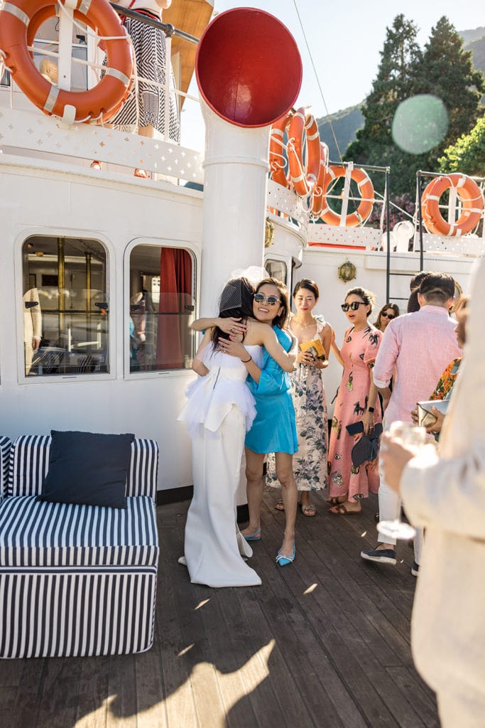 Bride hugs guests on Lake Como ferry boat