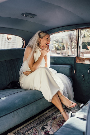 Bride rides in back of limousine in wedding dress and Stuart Weitzman bridal shoes, one of the best designer wedding shoes brand
