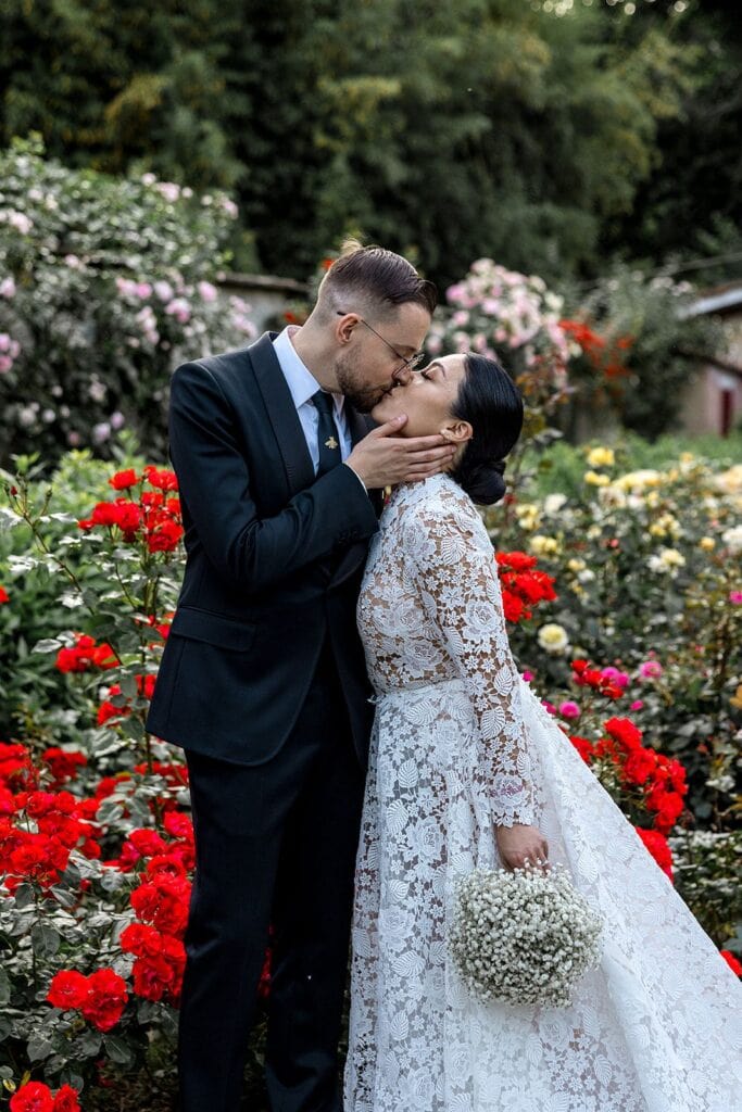 Bride and groom kiss in Tuscany garden at Villa Guicciardini