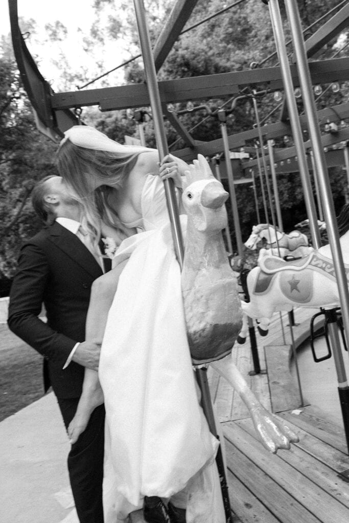 Bride and groom kiss on merry-go-round