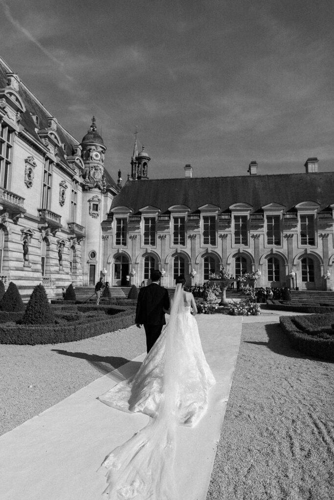 Bride and her father walk down ceremony aisle at French chateau wedding