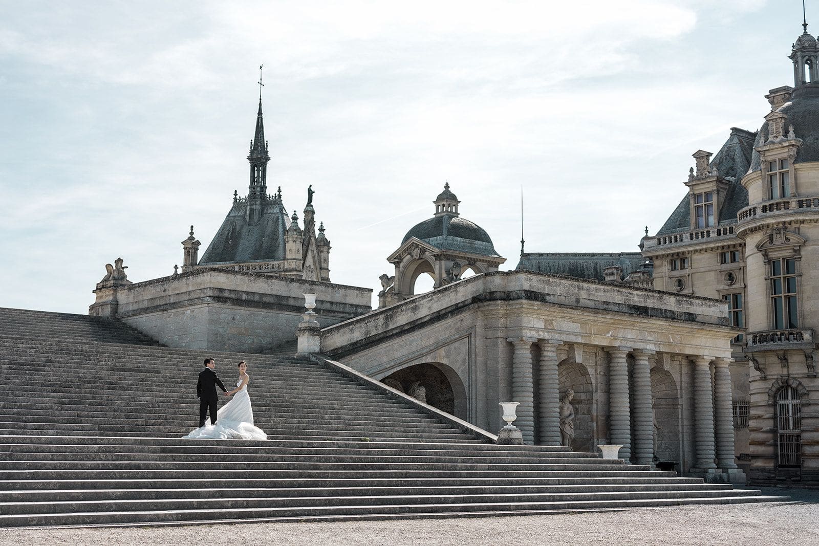 Bride and groom epic staircase portrait at Chateau de Chantilly, French destination wedding