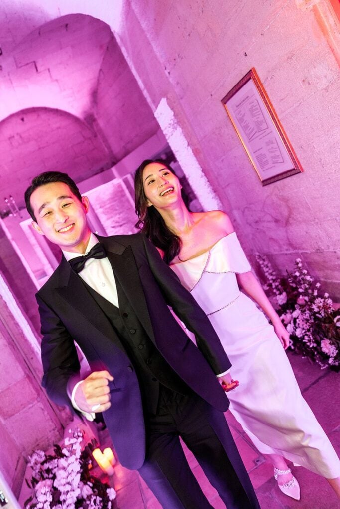 Bride and groom enter wedding reception with pink lighting