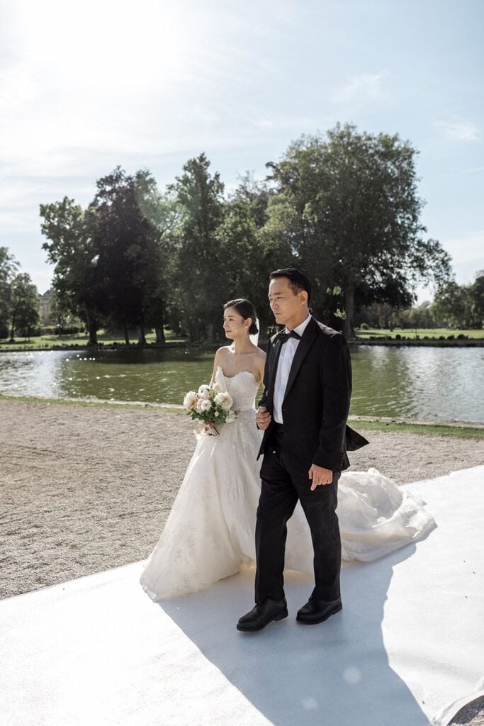 Bride walks down aisle with her father for Chateau de Chantilly, France wedding