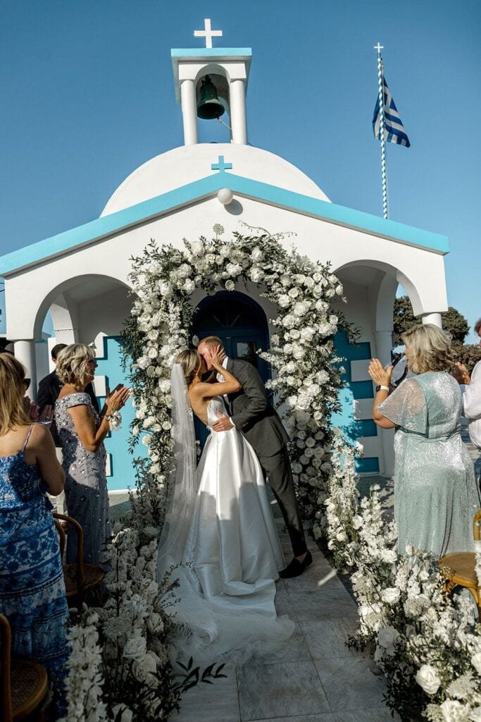 Bride and groom kiss at Greek destination wedding ceremony