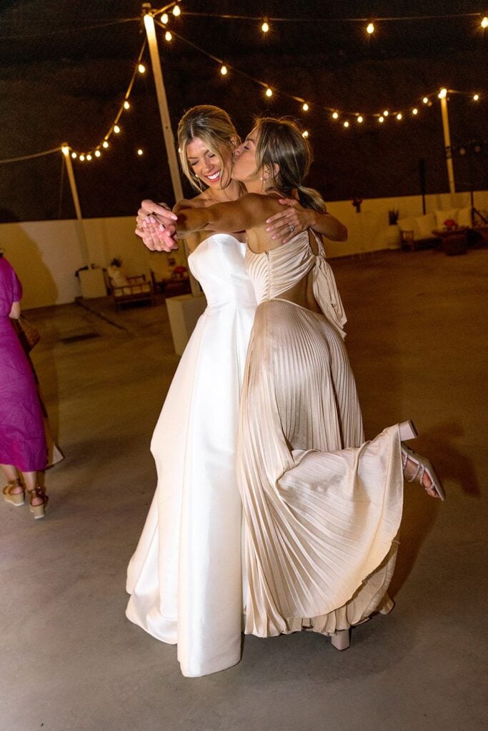 Bride and maid of honor dancing at Milos Greece wedding reception