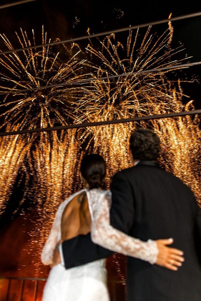 Bride and groom under fireworks at wedding reception