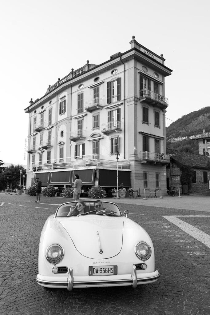 Black and white portrait of man and woman in vintage Porsche in varenna italy during lake como engagement shoot