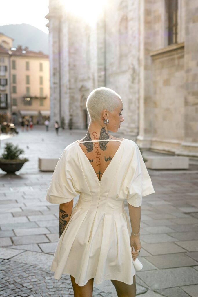 Woman poses during Lake Como engagement session while wearing a white dress
