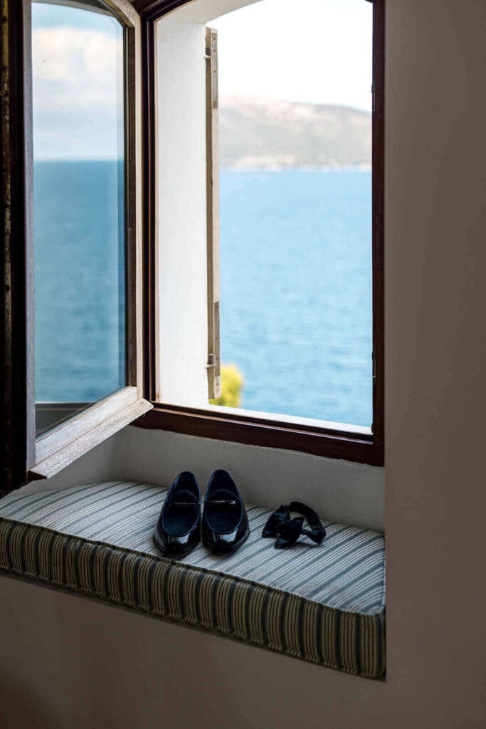 Groom's suite overlooking Mallorca's ocean with wedding shoes on windowsill, photographed by Lilly Red