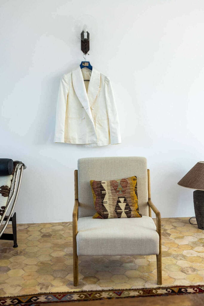 The groom's jacket hanging on a wall, photographed by Lilly Red
